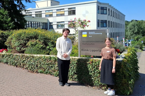 Zwei Personen vor dem Eingang des Reha-Zentrums, Azubis Zwei Personen vor dem Eingang des Reha-Zentrums, Azubis