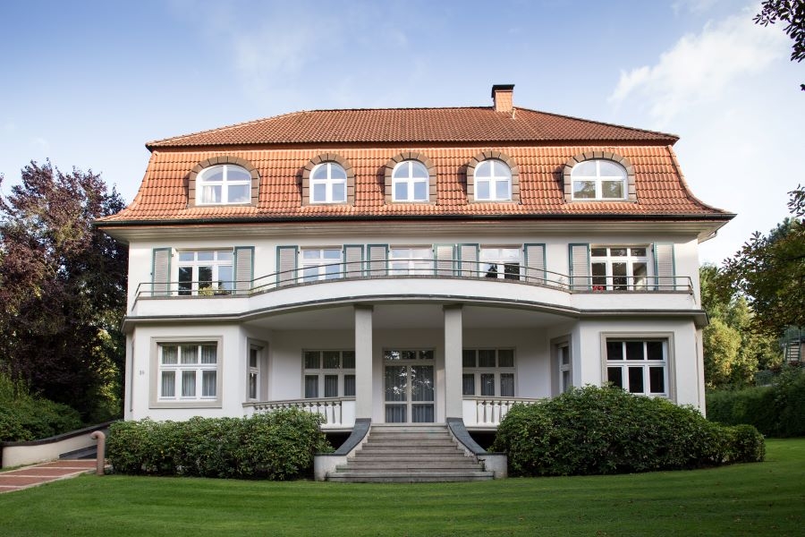 Eine Villa mit Wiese im Vordergrund